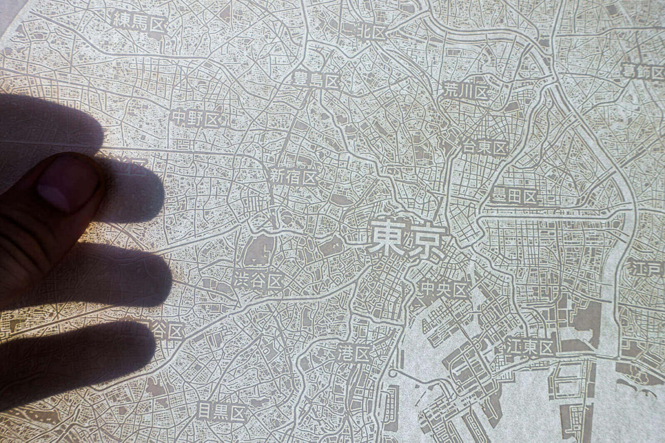 Light shines through the laser engraved paper map of Tokyo, Japan