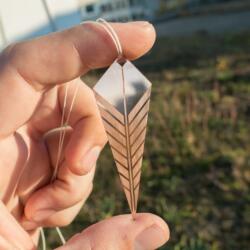 Lasercut and engraved jewelry prototype made out of copper metal in hand