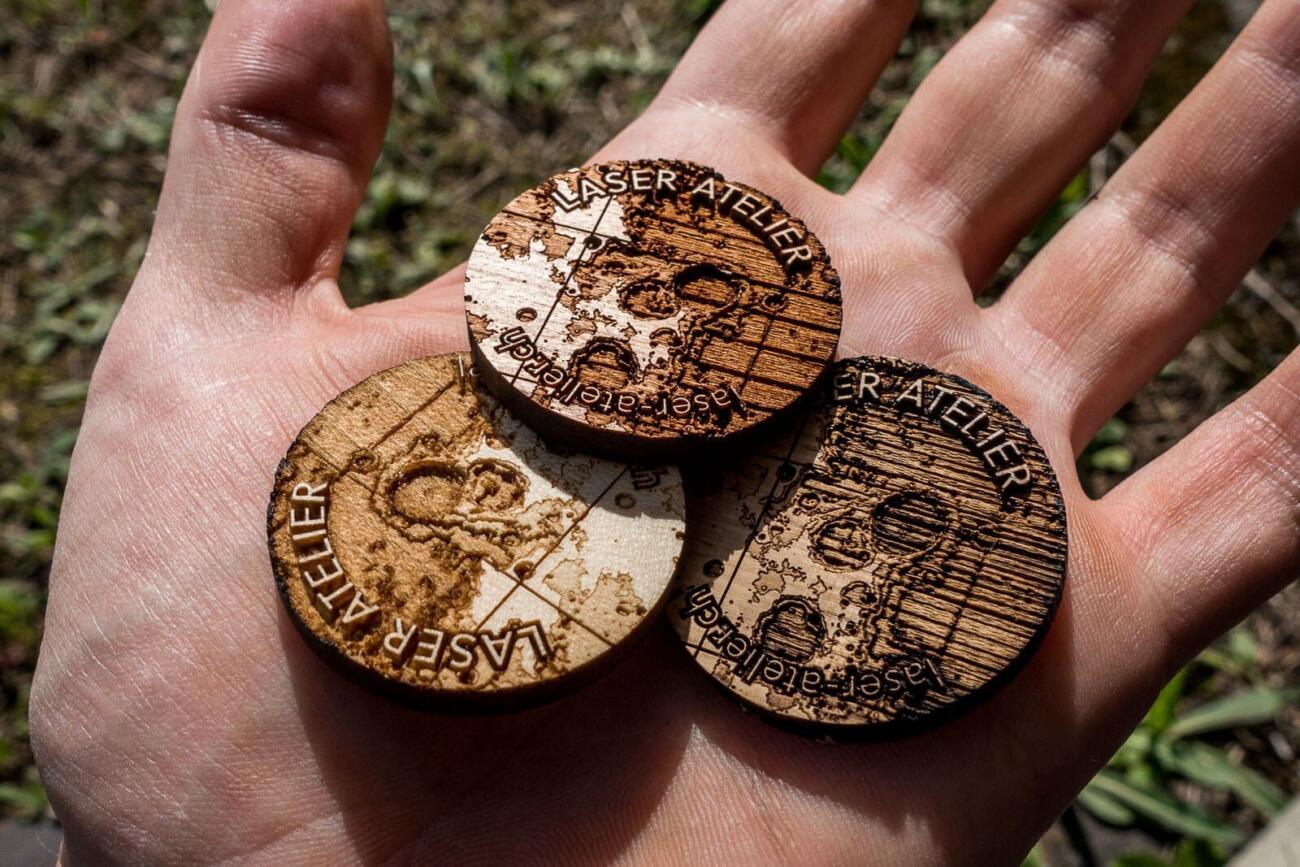 A series of small laser engraved tokens made from cherry, acorn and oak wood. They show a small section of moon topography