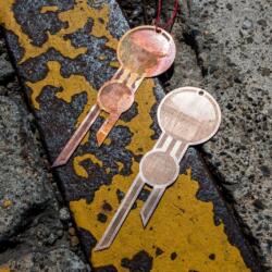 Lasercut geometric jewelery made from bronze engraved with a Trotec fiber laser